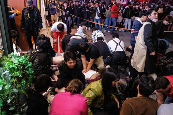 Los transeúntes intentan reanimar a las víctimas de la estampida masiva durante las celebraciones de Halloween en Seúl, Corea del Sur. - Sputnik Mundo