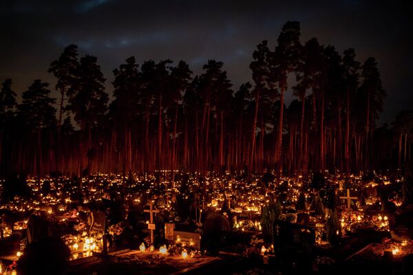 Velas encendidas en las tumbas el Día de Todos los Santos en un cementerio de Vilna, Lituania. - Sputnik Mundo