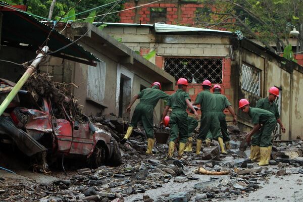 Según Marcano, se han reportado destrozos en todas las comunidades del estado entre Sotillo y Guanta. En la foto: los militares retiran los escombros tras un desprendimiento en Puerto la Cruz. - Sputnik Mundo