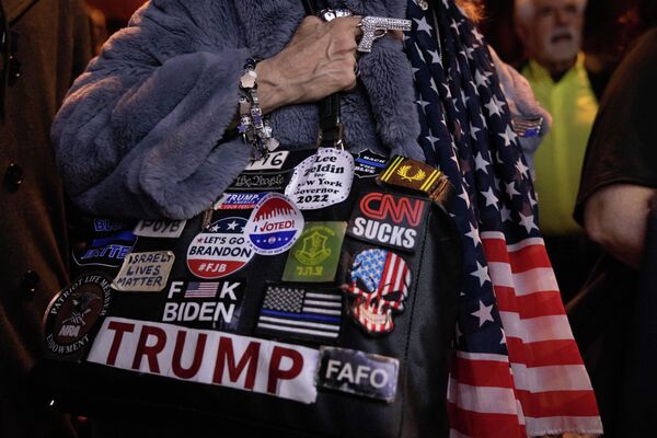 Una mujer sostiene un bolsо cubierto con pegatinas políticas en apoyo a Trump mientras los votantes republicanos ven los resultados en directo durante una actividad de observación de las elecciones del candidato republicano a gobernador de Nueva York, Lee Zeldin. - Sputnik Mundo