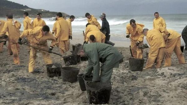 Limpieza de una playa tras el derrame petrolero (imagen referencial) - Sputnik Mundo