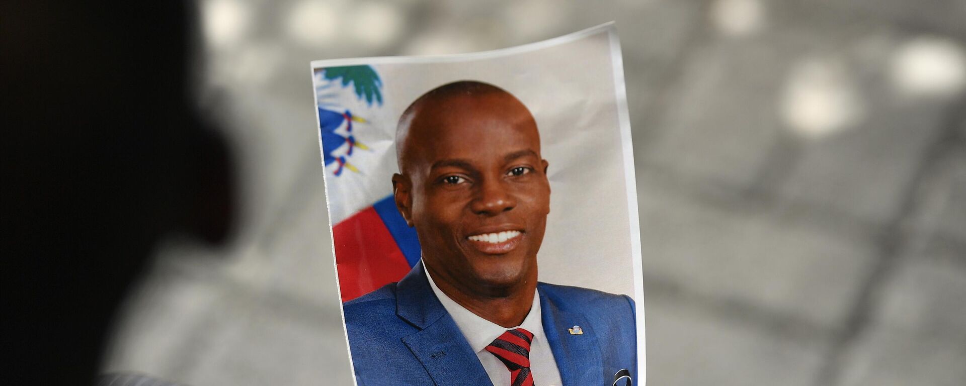 Una persona sostiene una foto del difunto presidente de Haití, Jovenel Moise, durante su ceremonia de conmemoración, 20 de julio de 2021 - Sputnik Mundo, 1920, 17.11.2022