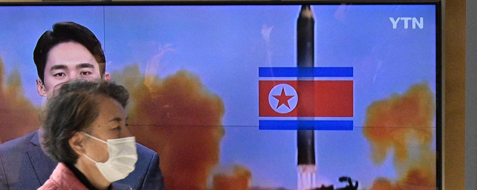 Una mujer camina frente a un televisor durante una transmisión de una prueba con misiles de Corea del Norte, el 17 de noviembre de 2022 - Sputnik Mundo, 1920, 18.11.2022