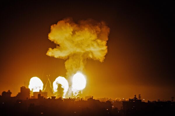 Una columna de humo se eleva sobre los edificios en el sur de la Franja de Gaza mientras cazas israelíes atacan el enclave palestino, a primera hora del 4 de diciembre de 2022. - Sputnik Mundo