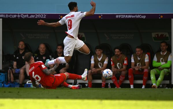 El defensa de Gales Joe Rodon (izda.) y el delantero iraní Mehdi Taremi en el partido de la fase de grupos. - Sputnik Mundo