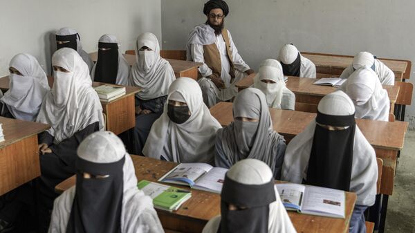Chicas afganas asisten a una escuela religiosa, que permaneció abierta desde la toma del poder por los talibanes el año pasado, en Kabul, Afganistán, 11 de agosto de 2022 - Sputnik Mundo