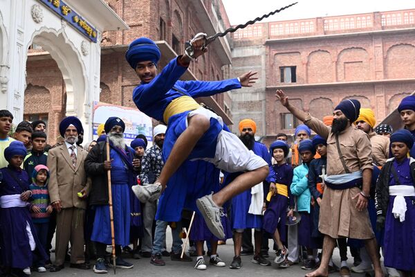 Un joven sij demuestra técnicas de artes marciales durante una ceremonia religiosa con motivo del aniversario del nacimiento del décimo gurú sij Guru Gobind Singh en el Templo Dorado de Amritsar, Punyab, la India. - Sputnik Mundo