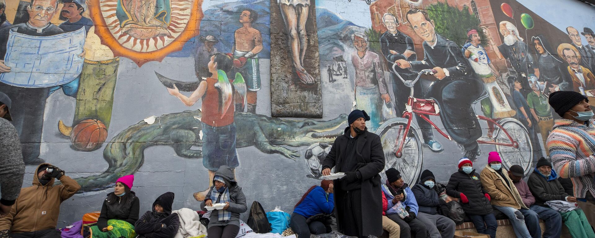 Migrantes comen y esperan ayuda mientras acampan en una calle del centro de El Paso, Texas, el domingo 18 de diciembre de 2022.   - Sputnik Mundo, 1920, 05.01.2023
