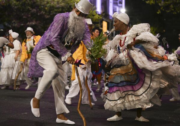 Las personas disfrazadas bailan durante el desfile inaugural del Carnaval de Llamadas de Uruguay, en Montevideo. - Sputnik Mundo