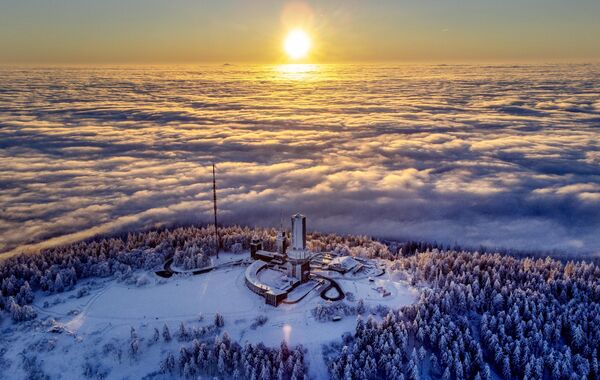 El sol se eleva sobre la cima de la montaña Feldberg mientras los alrededores están cubiertos por la niebla cerca de Fráncfort, Alemania. - Sputnik Mundo