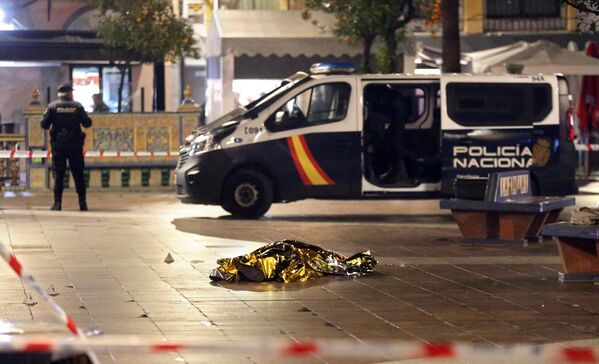 El cuerpo de un hombre muerto tumbado en el suelo mientras la Policía asegura la zona en Algeciras, sur de España. 25 de enero de 2023. - Sputnik Mundo