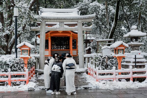 Personas vestidas con trajes tradicionales visitan el santuario de Yasaka, en Kioto. Así se vio el lugar, el 25 de enero de 2023, tras la intensa nevada y los fuertes vientos que azotaron varias zonas del país durante la noche. - Sputnik Mundo