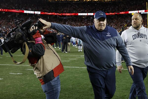 El entrenador de los Dallas Cowboys, Mike McCarthy, empuja a un camarógrafo mientras sale del campo después de un partido de fútbol americano de la NFL contra San Francisco. - Sputnik Mundo