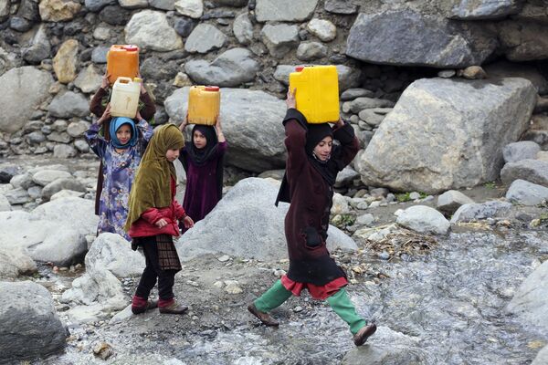 En esta fotografía tomada el 23 de enero de 2023, varias niñas afganas transportan bidones de agua potable tras llenarlos en un arroyo en el distrito de Dara-i-Nur, provincia de Nangarhar. - Sputnik Mundo