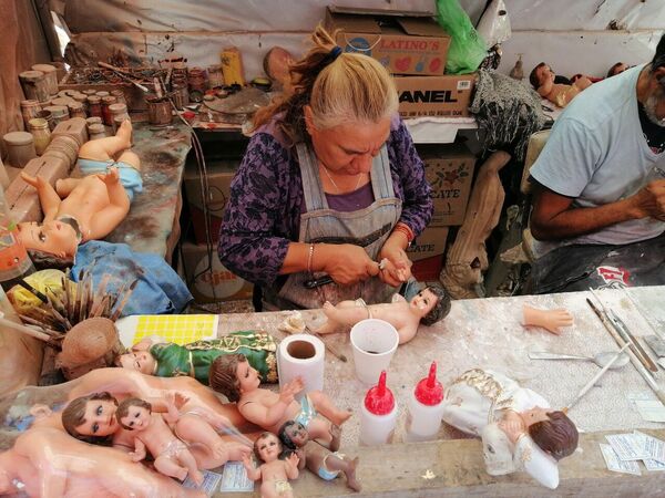 La señora Yolanda González trabaja en la reparación de los muñecos religiosos. - Sputnik Mundo