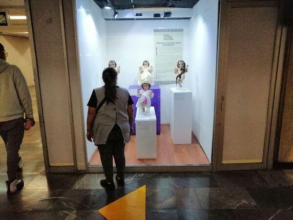 En la estación Zócalo del Metro, una pasajera se detiene a observar una vitrina con ejemplos de los atavíos del Niño Dios. - Sputnik Mundo