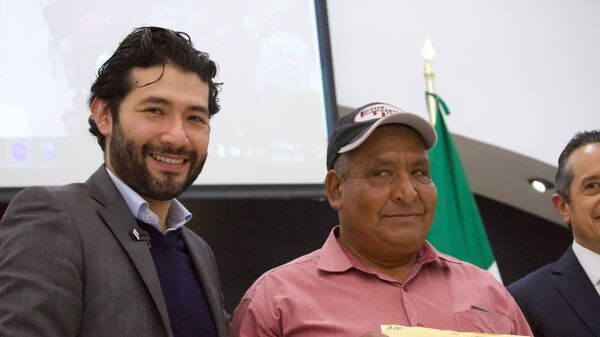 A la izquierda el subsecretario de Empleo y Movilidad Laboral, Marath Bolaños López, despidiendo a jornaleros del Programa de Trabajadores Agrícolas Temporales México-Canadá - Sputnik Mundo