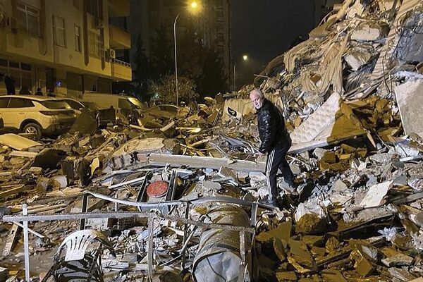 Un hombre camina entre los escombros de los edificios derrumbados por el terremoto en Diyarbakir, al sur de Turquía. - Sputnik Mundo