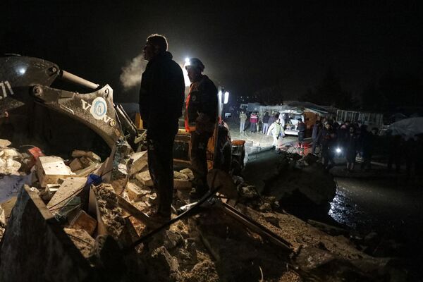Los rescatistas sirios (Cascos Blancos) y residentes se reúnen cerca de un edificio derrumbado tras el terremoto, en la ciudad fronteriza de Azaz, en el norte de la provincia siria de Alepo. - Sputnik Mundo