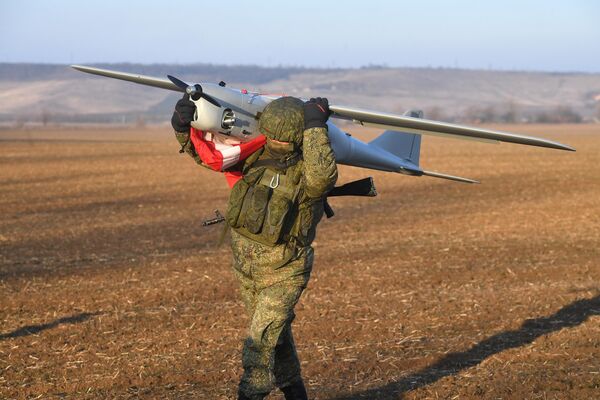 En la variante de ataque, los drones Orlan-10 son capaces de atacar de forma independiente posiciones enemigas con munición de fragmentación de alto poder explosivo. Cada dron puede llevar a bordo cuatro proyectiles de este tipo.En la foto: un soldado ruso se lleva el dron Orlan-10 tras completar su misión de combate. - Sputnik Mundo