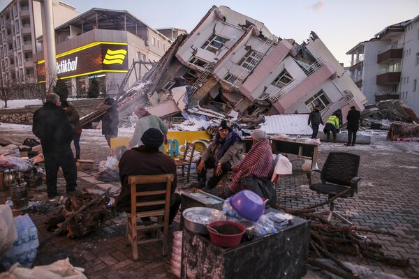 Varias personas están alrededor de un edificio derrumbado en Golbasi, en la provincia turca de Adiyaman. - Sputnik Mundo