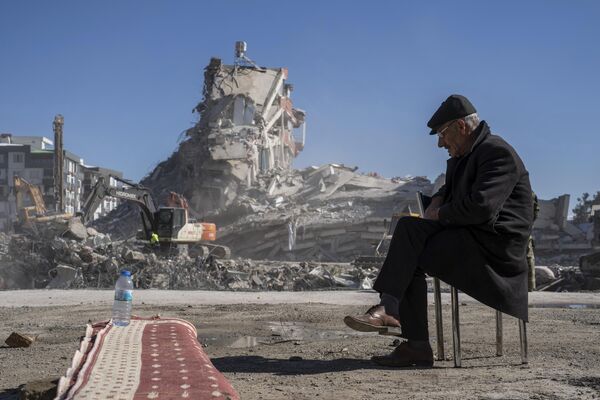 Un residente de la ciudad de Nurdagi cerca de su casa destruida, donde cinco miembros de su familia permanecieron bajo los escombros. - Sputnik Mundo