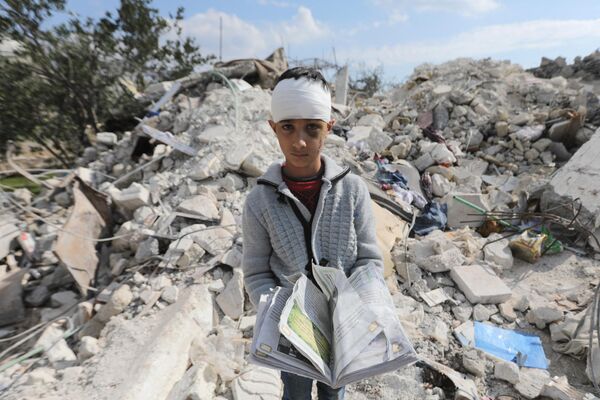 Un adolescente sirio, que resultó herido y perdió a sus padres en el devastador terremoto, se encuentra sobre las ruinas de su casa en la ciudad de Jindayris, en poder de las fuerzas antigubernamentales. - Sputnik Mundo