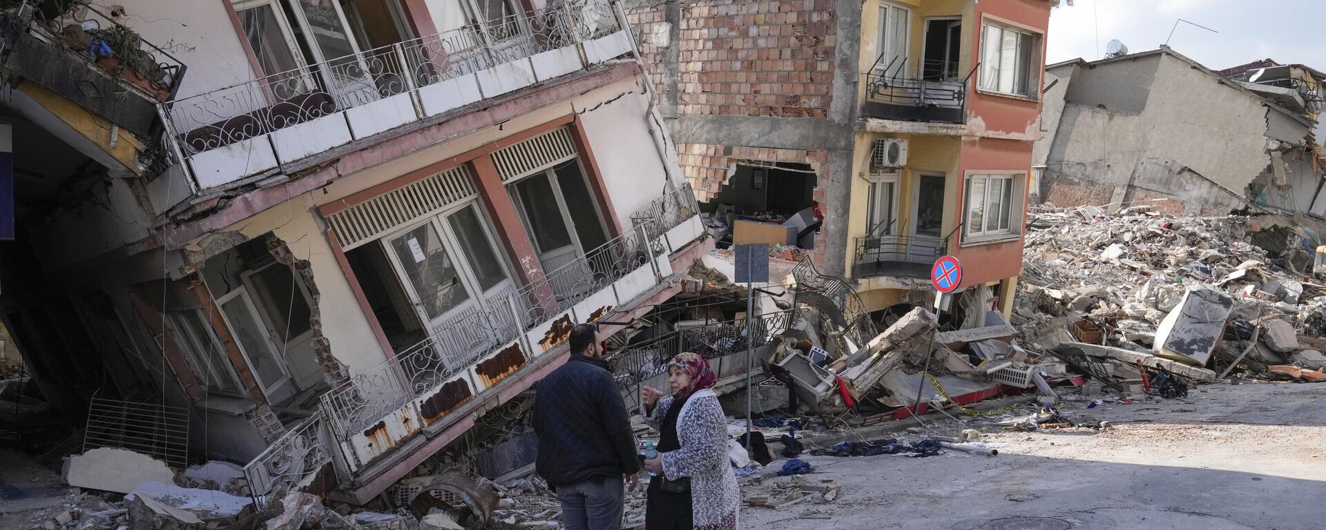 Dos personas conversan en medio de edificios dañados en Hatay, Turquía, el 11 de febrero de 2023 - Sputnik Mundo, 1920, 21.02.2023