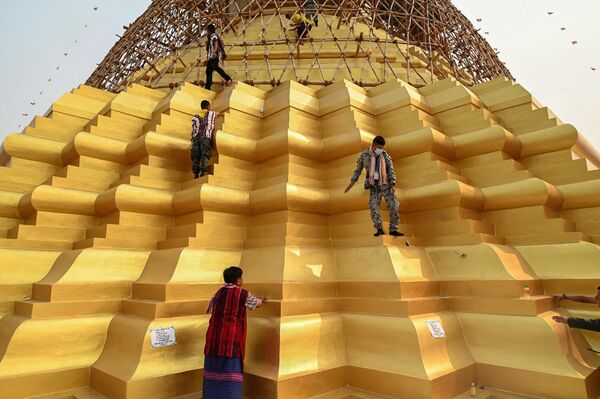 Un grupo de personas sube a la pagoda antes de la ceremonia budista de colocación de un paraguas dorado en su cima, en el municipio birmano de Hlaingbwe, estado de Karen. - Sputnik Mundo