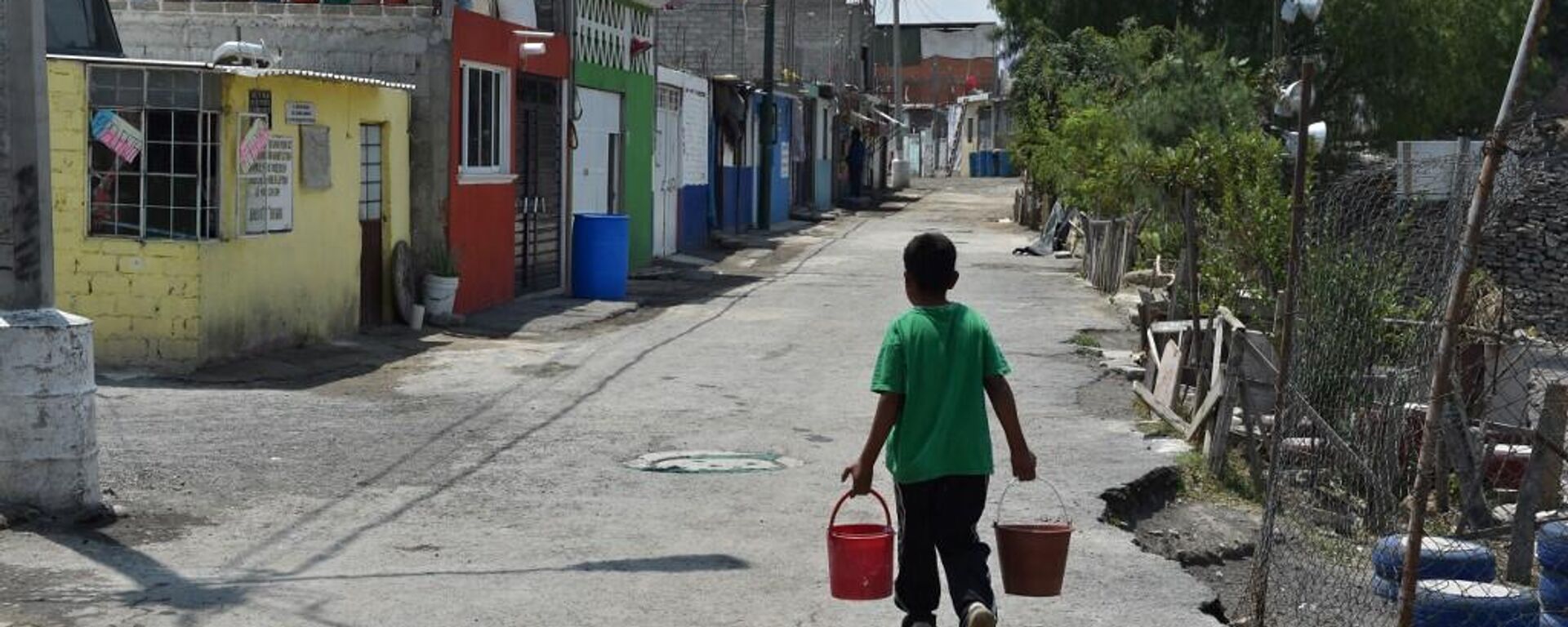 Un niño carga cubetas con agua para llevar a su casa en un barrio de Iztapalapa, alcaldía de la Ciudad de México que enfrenta constantes problemas de acceso al agua - Sputnik Mundo, 1920, 04.02.2024