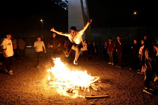 Un iraní salta sobre una hoguera en Teherán durante el Festival del Fuego de los Miércoles, o Chaharshanbe Suri, que se celebra anualmente el último miércoles antes de la fiesta primaveral de Nowruz. El Año Nuevo iraní, que comienza el 20 de marzo, coincide con el primer día de la primavera.  - Sputnik Mundo