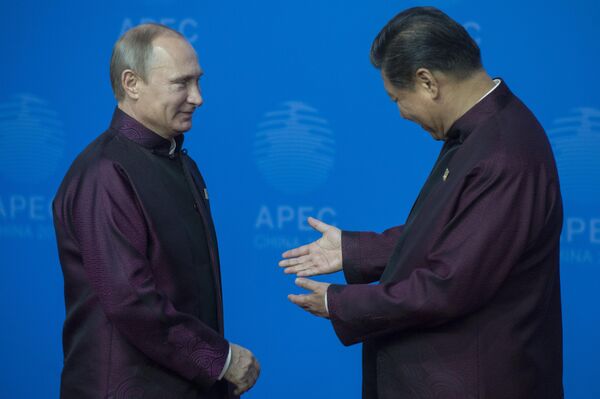 El presidente ruso, Vladímir Putin, y el presidente chino, Xi Jinping, durante el Foro de Cooperación Económica Asia-Pacífico (APEC), vestidos con trajes con elementos del traje nacional chino. - Sputnik Mundo