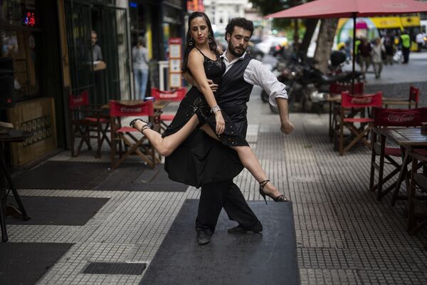 Los artistas Emilia García Márquez y Federico Cachero bailan tango para los turistas en el centro de Buenos Aires. - Sputnik Mundo