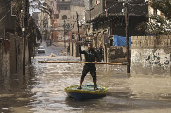 Un palestino en una calle inundada del campo de refugiados de Al-Shati, en la Franja de Gaza. - Sputnik Mundo