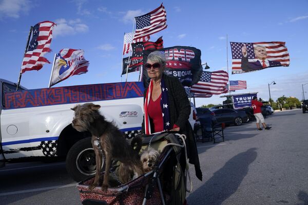 Paula Magnuson, partidaria del expresidente estadounidense Donald Trump, pasea a sus perros frente a la finca Mar-a-Lago de Trump en Palm Beach, Florida. - Sputnik Mundo