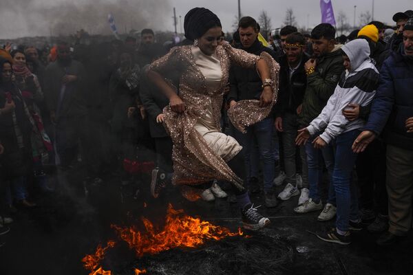 Una mujer salta sobre una hoguera durante las celebraciones de Nowruz en Estambul, Turquía. - Sputnik Mundo