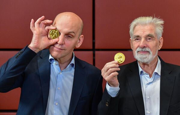 Los científicos alemanes, Klaus Hasselmann (a la derecha) y Benjamin List, ganadores del premio Nobel de física y química, respectivamente, festejan con medallas de chocolate después del Simposio Nobel en la embajada de Suecia en Berlín, 2021. - Sputnik Mundo