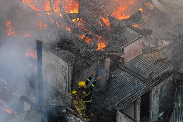 Los bomberos luchan contra un incendio en una zona residencial de la capital filipina de Manila. - Sputnik Mundo