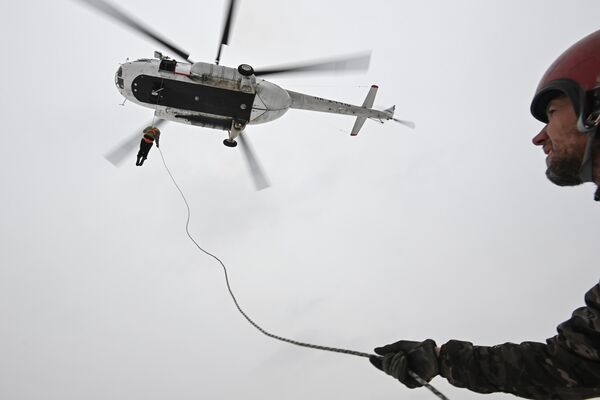 Miembros del equipo básico de rescate aéreo de la Fuerza Aérea de Novosibirsk realizan un aterrizaje desde un helicóptero Mi-8, en la región rusa de Novosibirsk. - Sputnik Mundo