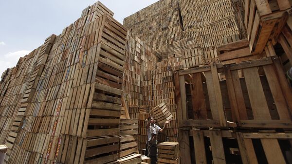 Trabajador apila cajas de madera en la Central de Abasto de la Ciudad de México - Sputnik Mundo