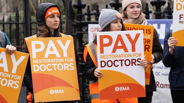 Manifestantes sostienen pancartas en apoyo a una huelga de enfermeras frente al Hospital St Thomas en Londres, 13 de marzo de 2023.  - Sputnik Mundo
