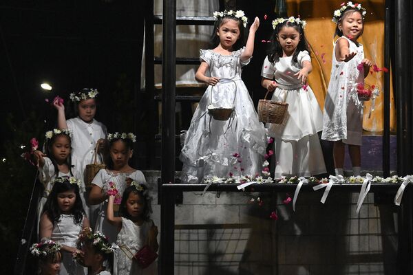 Los niños vestidos de ángeles lanzan pétalos de flores durante las celebraciones de Pascua en la Iglesia de San José Obrero en San José del Monte, Bulacán, Filipinas. - Sputnik Mundo