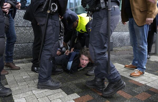 La policía detiene a un manifestante en Ámsterdam durante la visita a Holanda del presidente francés, Emmanuel Macron. - Sputnik Mundo
