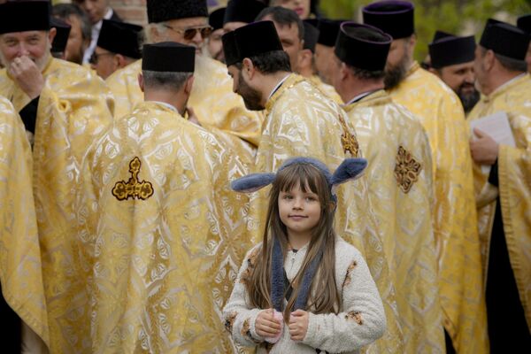 Un niño junto a sacerdotes ortodoxos preparándose para la peregrinación del Domingo de Ramos en Bucarest, Rumanía. - Sputnik Mundo