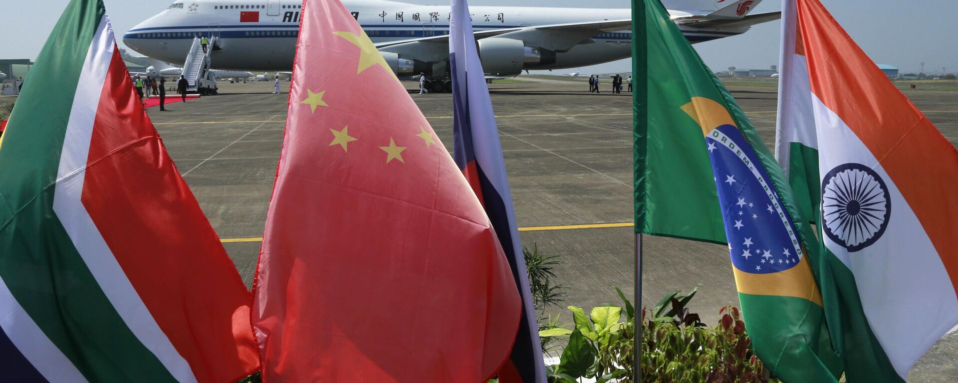Banderas de los cinco países que componen el BRICS frente a la aeronave de Air China, en la cual el presidente chino Xi Jinping llego para participar de la cumbre de la organización en Goa, Índia, el 15 de octubre de 2016 - Sputnik Mundo, 1920, 16.08.2023