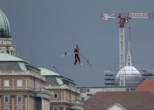 El artista de circo Laszlo Simet, de 63 años, hace equilibrio sobre el río Danubio en el centro de Budapest, Hungría. - Sputnik Mundo