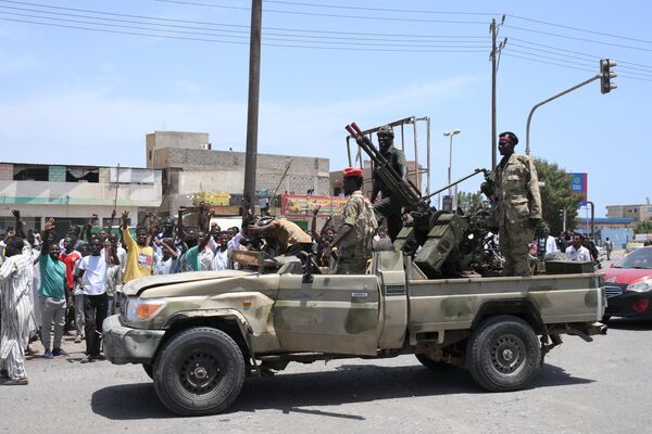 Varios lugareños saludan a los partidarios del jefe de las FFAA sudanesas, el general Abdel Fattah Burhan, en la ciudad de Puerto Sudán, en la costa del mar Rojo. El conflicto político-militar que estalló en Sudán el 15 de abril ha causado ya 270 muertos y más de 2.600 heridos. - Sputnik Mundo