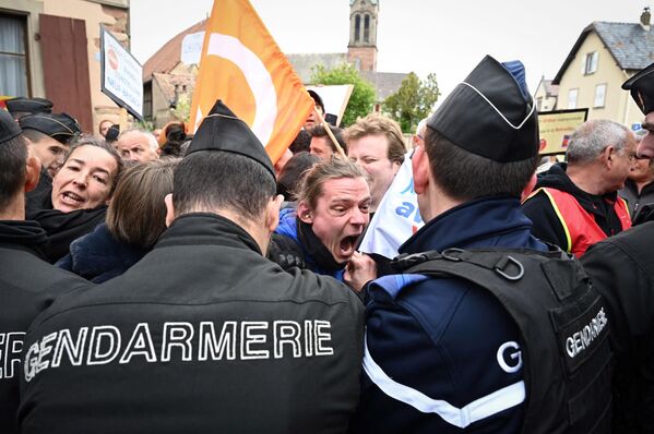 Gendarmes franceses agolpan a manifestantes durante la visita del presidente francés, Emmanuel Macron, a la empresa de Mathis, en Muttersholtz, en el este del país. - Sputnik Mundo