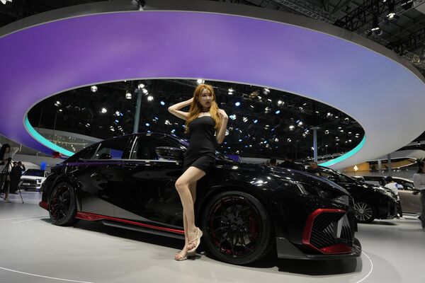 Una bloguera posa en el estand del fabricante chino de automóviles GAC Trumpchi. - Sputnik Mundo