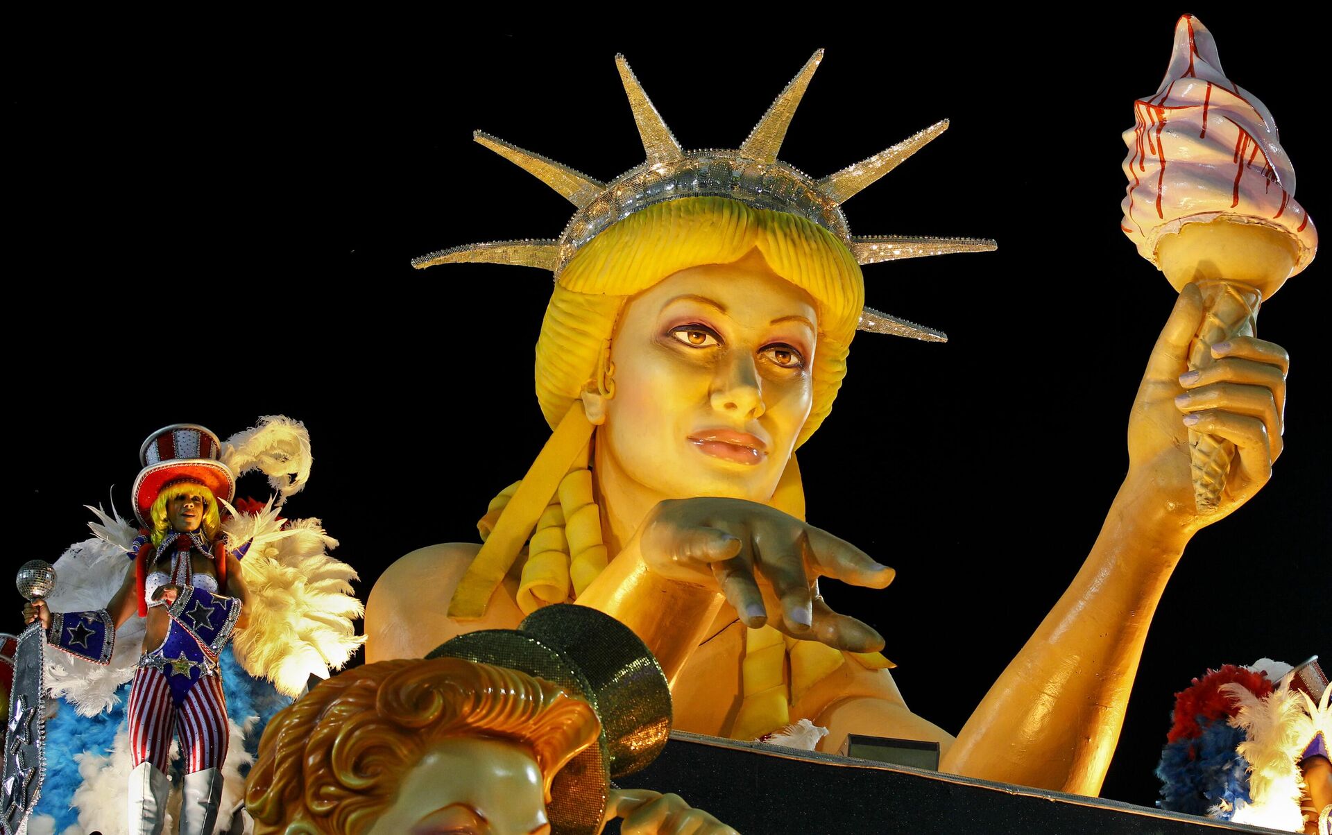 Una carroza con una estatua en referencia a la Estatua de la Libertad de EEUU durante el desfile de la escuela de samba Sфo Clemente en el Sambódromo de Río de Janeiro - Sputnik Mundo, 1920, 29.04.2023